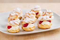 Profiteroles filled with cream and raspberries
