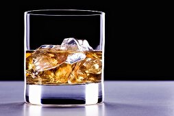 A glass of whisky with ice cubes
