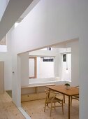 Simple wooden chair and table in Bauhaus style in a modern house with cut outs in the wall