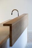 Kitchen counter clad in wood in front of a sink and faucet