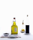 Bottles of oil and vinegar on saucers