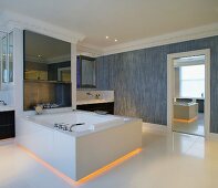 Bathtub for two with yellow back lighting in the floor area in the spacious bathroom