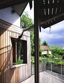 Detail of a home with wooden terrace and view of the garden