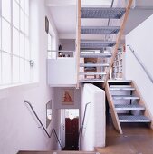 Stairwell with stairs leading off into another location and view into an open living room