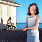 Young Girl Holding Shell at the Beach; Beach House