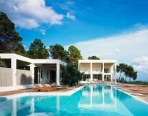 Pool in front of contemporary white villa in a Mediterranean landscape