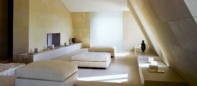 Ottomans upholstered in white in a living room under a roof with cubic flooring