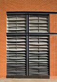 Ceiling high windows with closed blinds in a home's clinker brick facade