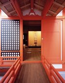 Traditionelles japanisches Wohnhaus mit hellrot lackierter Tür und Blick auf Bodenkissen