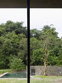 Terrassenstütze aus Metall und Blick in Garten mit Pool und Natursteinmauer
