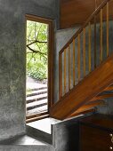 Floating wooden stairs and platform in front of open front door in small foyer