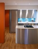 Kitchen island with stainless steel fronts in open-plan designer kitchen