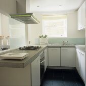 Funktionale weiße Küche mit Dunstabzug über Küchenblock