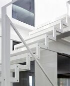 Zickzack-Stahlwange und minimalistischer Handlauf einer leichten, weissen Treppe
