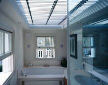 Licht-/Schatteneffekten durch horizontale Jalousie vor grossem Oberlicht in modernem Bad mit englischen Schiebefenstern