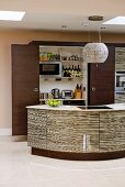 Curved kitchen island with glossy structured fronts in front of open refrigerator