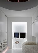 Weisses Gästezimmer mit Flokatidecke auf Bett und transparentem Plexiglasstuhl vor Fenster