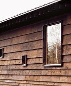 Old wooden house in Japanese style with modern windows of different sizes