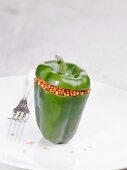 A raw green pepper stuffed with lentils