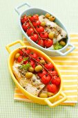 Halibut with cherry tomatoes, olives and capers in baking dishes