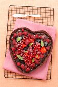 A heart-shaped chocolate cake decorated with berries