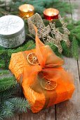 A Christmas present decorated with a bow and dried orange slices