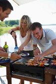 Junge Leute grillen am Strand