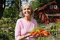 A woman serving a plate of crayfish (Sweden)