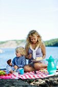 A mother and son having a picnic by a lake