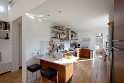 Moderne, funktionale Küche mit warmen Akzenten durch Holzfronten und Terrakottafliesen