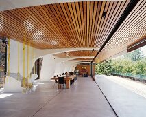 Roofed terrace with wooden louvers serves as dining area and living room
