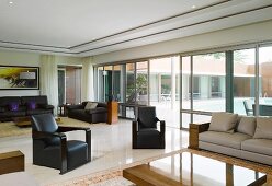 Elegant living room with seating and glass wall leading to terrace