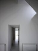 Foyer with skylight in sloping roof and view of corridor with light at the end