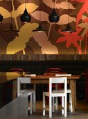 Black pendant lamps in front of trendy floral mural in English coffee bar