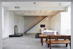 Open-plan kitchen with dining table, stairway with light strip in background