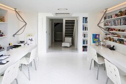 View of hallway through room with desks & shelves