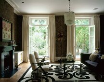 Living room with sofa, armchairs & floor-to-ceiling balcony doors