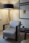 Corner of living room with standard lamp, armchair and side table