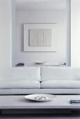 White sofa in front of open doorway to dining room