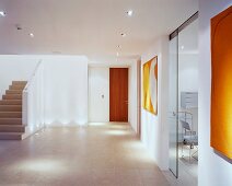 Spacious, modern foyer with staircase and open glass sliding door