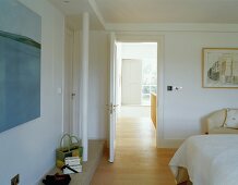 Modern bedroom with view of stairwell through open door