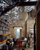 Bicycles in front of bookcase in house with stone walls