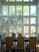 Dining table with light upholstered chairs in high, glazed extension