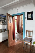 View through open interior door into hallway with tiled floor and open front door