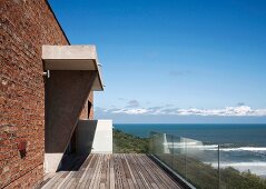 Blick von der Terrasse mit Glasgeländer auf das Meer