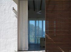 View past slatted wooden door into living room