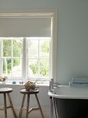 Traditional bathroom with old wooden stools and free-standing bathtub with modern taps