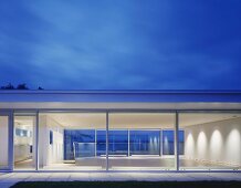 Modern house with glass walls at dusk