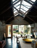 Living space with glass roof structure & view of garden