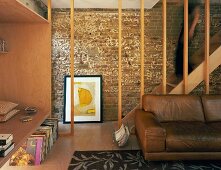 Living room with leather sofa, wooden fitted cupboard & wooden staircase